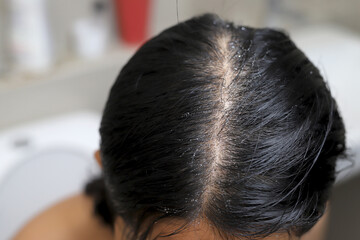Fototapeta premium A woman is taking a shower and washing her hair in the bathroom.