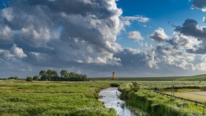 Gewitterwolken über dem Pilsumer Leuchtturm in Ostfriesland, Deutschland