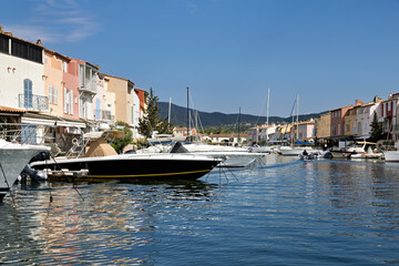 Port Grimaud harbor from the water with ships, yachts, pier and shops as well as residential...