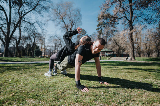 Two teenagers enjoying a fun and active workout session outdoors in a scenic park setting. Emphasizing teamwork and physical fitness under a clear sky.
