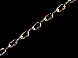 Close-up of a weathered and rusty metal chain in diagonal orientation, isolated on black background, symbol of strength and decay
