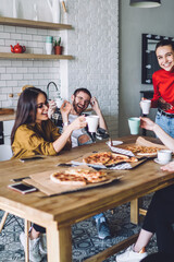 Young creative cheerful people making home party with pizza