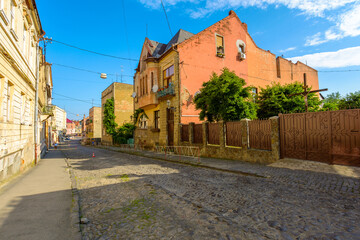 uzhhorod, ukraine - 11 jun 2017: european urban landscape with street of town in morning light. cobblestone path down the hill to koriatovycha square in city center