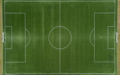 Aerial view from zenith/nadir angle down of a soccer field on a sunny day, where the green color of...