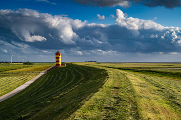 Gewitterwolken über dem Pilsumer Leuchtturm in Ostfriesland, Deutschland