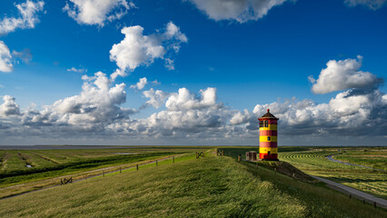 Gewitterwolken über dem Pilsumer Leuchtturm in Ostfriesland, Deutschland