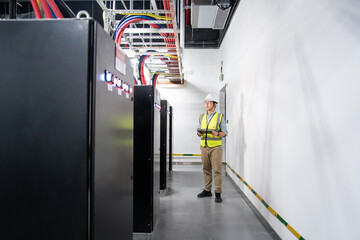 Fototapeta premium asian technician performs maintenance on backup power system battery