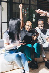 Diverse cheerful company of friends celebrating victory after playing video games