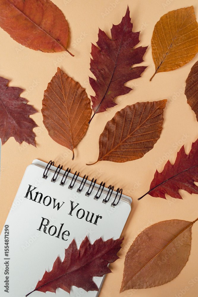 Poster spiral notebook lies on the table with pile of sheets of paper with the text know your role