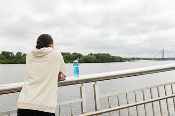 Sporty young man takes a break while working out by the river