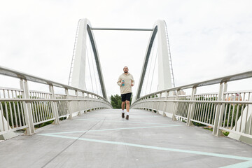 Sporty man exercises on a bridge while enjoying the great outdoors