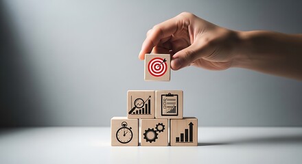 Hand Placing Wooden Block with Target Icon on Stack of Blocks Showing Business Icons Stopwatch Graph Checklist Gears