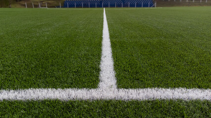 White lines painted on the grass of a soccer field, highlighting the green of the grass on a sunny...