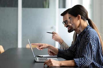 Business partners collaborating on a laptop during a meeting, working together on a project, and sharing creative ideas.
