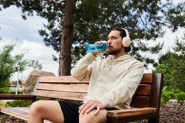 Sporty young man enjoying refreshing drink during outdoor workout session