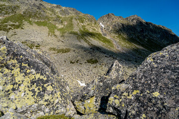 Rocky Alpine Slopes with Grassy Trails and Rugged Peaks at Splugen Pass: Serene Mountain Landscape under Clear Blue Summer Sky in the Swiss Alps