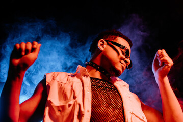 Stylish Man Dressed In Net Dancing In Neon Light, Smoke Studio Or In Night Club