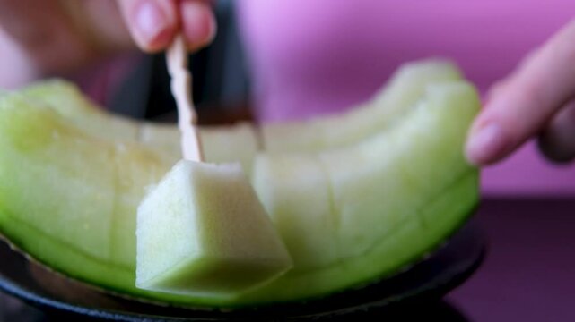 slices of delicious melon are on white plate, pricked with fork and eaten. High quality 4k footage