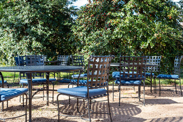 empty outdoor metal chairs on  gravel ground
