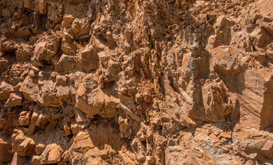 Close-up of rugged rocky cliff surface. Detailed view of a rugged rock face showcasing its jagged....