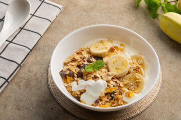 muesli with fresh banana and yoghurt in white bowl.delicious healthy breakfast.