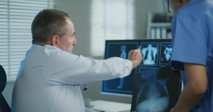 Senior Doctor and Nurse Examining X-Ray Scan