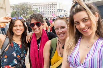 Four smiling women posing together at a demonstration for women's rights
