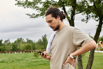 Sporty young man enjoying an outdoor workout session while checking his phone