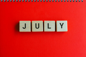 Top view of square letters with text JULY