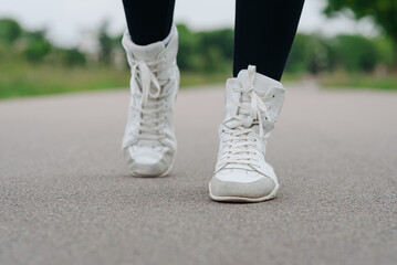 young slim beautiful caucasian woman running on path on river embankment in city park, black...