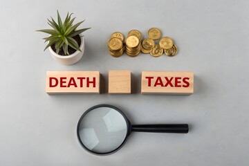 Death taxes concept. Wooden blocks with inscription and coins. Taxes that are applied when someone dies, usually on the money or property they leave behind. 