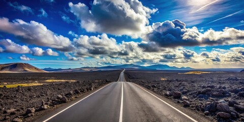 Asphalt ribbon unwinding towards a distant horizon, under a breathtaking expanse of fluffy clouds and a vibrant blue sky, traversing a stark, rocky landscape
