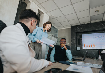 A multicultural group of people engaged in a meeting, collaboratively discussing reports and...