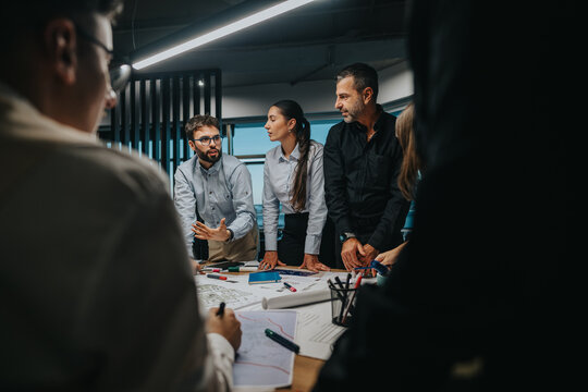 A group of business professionals engaged in a dynamic team meeting, collaboratively brainstorming project ideas and solutions around a conference table, highlighting teamwork and professional