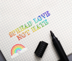 Spread Love Not Hate text with rainbow, pen, paper, and black marker