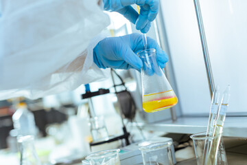 Laboratory Testing and Quality Control of Oil Sample by Scientist with Pipette and Glassware in...