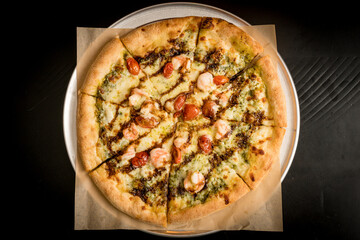 Pizza topped with shrimp and pesto