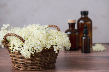 A wicker basket brimming with soft white flowers sits on a wooden surface next to a variety of...