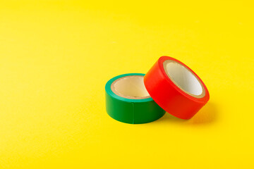 Insulating tape on a bright colored background. Set of different colors insulating tape. Reel...