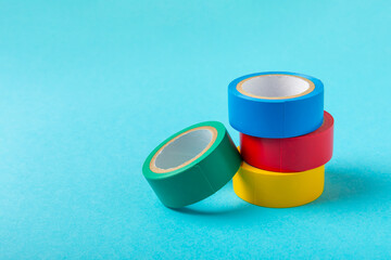 Insulating tape on a bright colored background. Set of different colors insulating tape. Reel...