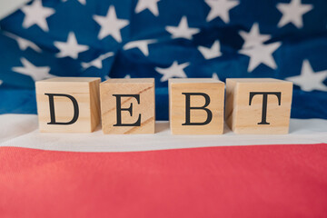 Wooden block with the word debt written on it