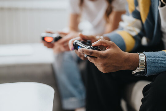 Two diverse gamers engaged in an exciting video game session, demonstrating enjoyment, connectivity, and shared interests in a casual home setting.
