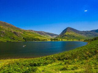 Bracken-covered lakeshore and mountains on the opposite side of the lake (Buttermere, Lake District, England, United Kingdom)