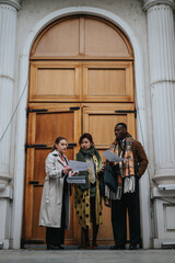 A group of young people review documents and exchange ideas while standing outside near a classic wooden door, creating a formal and collaborative atmosphere.