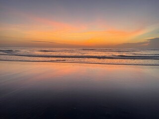 Sunrise at a tropical beach with soft golden tones reflecting on the calm sea. Peaceful and inspiring coastal view.