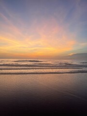 Sunrise at a tropical beach with soft golden tones reflecting on the calm sea. Peaceful and...