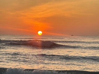 Sunrise at a tropical beach with soft golden tones reflecting on the calm sea. Peaceful and...