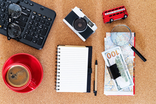 Flat lay with travel essentials and coffee. Workspace concept with money, camera, and notepad.