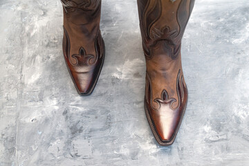 Cowboy boots with hand embroidered close-up on gray background. Space for text.