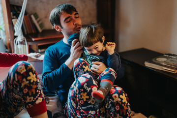 A father and child enjoy playful bonding time indoors, showcasing warmth and family happiness. Both dressed in festive pajamas, the scene emphasizes togetherness and familial affection in a relaxed